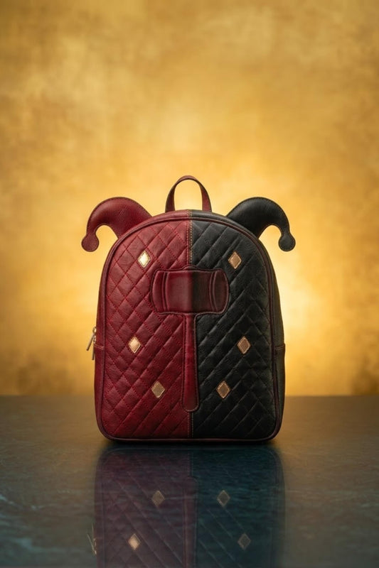 Harley Quinn inspired red and black split leather backpack with jester horn ears, quilted diamond stitch, gold stud accents and hammer emblem, front view