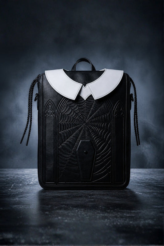 Wednesday inspired genuine leather backpack in jet black with embossed spider web design, white Peter Pan collar, gothic arch engravings, coffin snap closure and braided tassel accents — front view