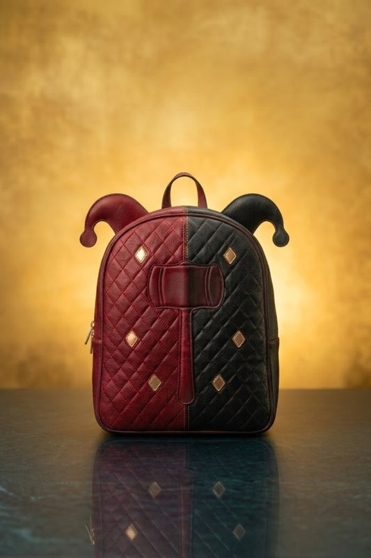 Harley Quinn inspired red and black split leather backpack with jester horn ears, quilted diamond stitch, gold stud accents and hammer emblem, front view
