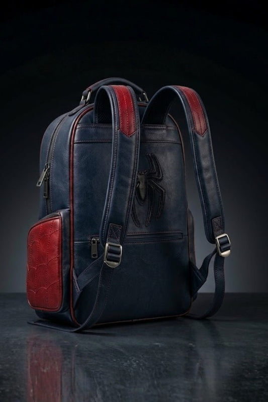 Back view of Spider-Man inspired leather backpack showing navy blue exterior with red accents, padded shoulder straps, and tonal embossed spider logo
